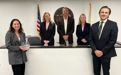 People standing at desk with award